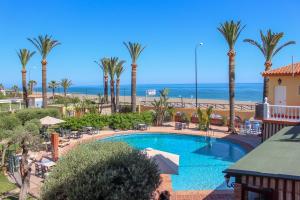 贝纳哈拉菲埃斯佩兰萨旅馆的享有棕榈树游泳池和大海的景色