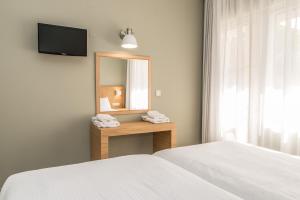 干尼亚克雷塔埃琳娜酒店的一间卧室配有一张床、镜子和一张床