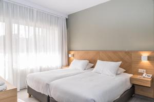 干尼亚克雷塔埃琳娜酒店的一间卧室设有一张大床和一个窗户。