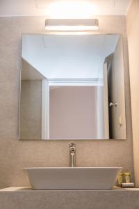 干尼亚克雷塔埃琳娜酒店的浴室水槽和上面的大镜子