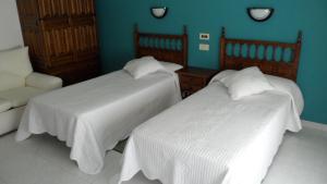 Vista AlegreHostal La Paz的一间设有两张床和椅子的房间