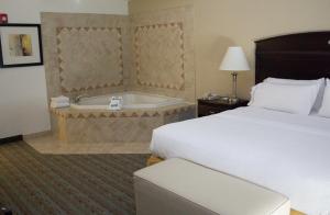 西杰斐逊西杰斐逊智选假日酒店的酒店客房配有一张床和浴缸。
