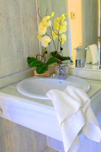 马德里马德里埃斯库埃拉酒店的浴室水槽上放着黄色花瓶