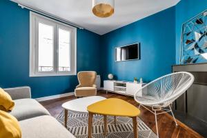兰斯MM Suites Cathédrale的蓝色的客厅配有沙发和椅子