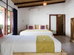 吉利特拉旺安吉利海龟度假酒店的带2扇窗户的客房内的2张床