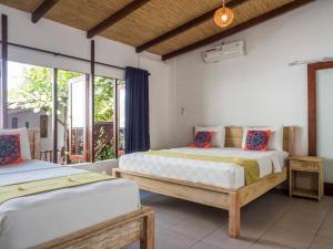 吉利特拉旺安吉利海龟度假酒店的带窗户的客房内的两张床