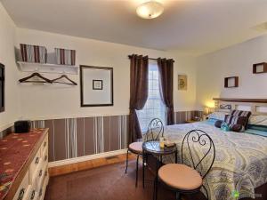 尼亚加拉瀑布Cozy House B&B的卧室配有一张床和一张桌子及椅子