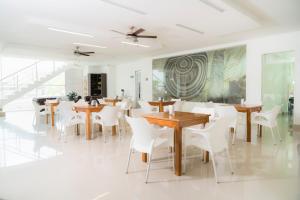 蒙特里亚Hotel Cinco Monteria的用餐室配有木桌和白色椅子