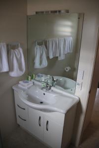 拉罗汤加瓦伊亚库拉度假屋的浴室设有白色水槽和镜子