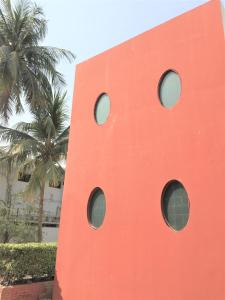 卡拉奇星宿旅馆的棕榈树旁的红色建筑,设有圆形窗户