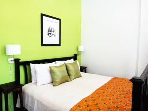 琅勃拉邦飞天酒店的一间卧室设有一张带绿色墙壁的大床
