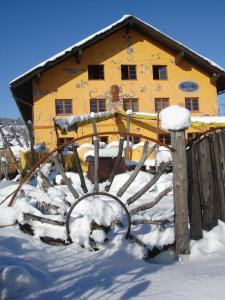 Bihlerdorf希夫比勒尔朵夫旅舍的雪中的一个黄色房子,上面有雪