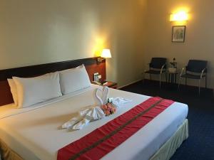 合艾合艾金皇冠酒店的酒店客房,配有一张带鲜花的大床