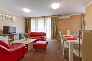 特普利采特普利莱广场酒店的客厅配有红色的沙发和桌子