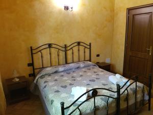 卡拉马尼科泰尔梅Il Rifugio dei Briganti的一间卧室配有一张带锻铁床头板的床