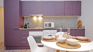 坎布里尔斯Cambrils 4的厨房配有紫色橱柜和白色桌子