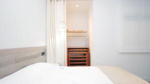 坎布里尔斯Cambrils 4的卧室配有白色的床和开放式衣柜。