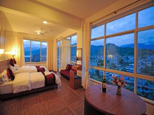 博卡拉Hotel City Inn - Mountain View的酒店客房设有一张床和一个大窗户