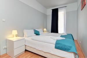 布达佩斯阿加佩公寓的卧室配有白色的床和窗户。