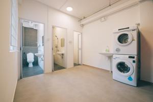 新加坡Wanderloft Capsule Hostel的一间带卫生间的浴室内的洗衣机
