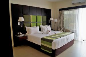 恩德培恩德培最佳西方精品花园酒店的一间卧室配有一张大床和大床头板