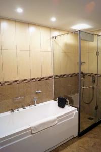 恩德培恩德培最佳西方精品花园酒店的设有带浴缸和淋浴的浴室。