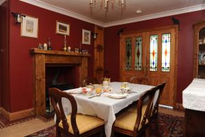 克拉姆林海湾小屋住宿加早餐酒店的一间带桌子和壁炉的用餐室