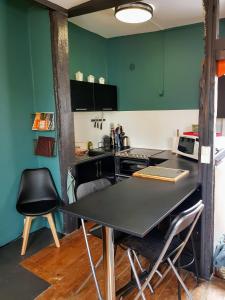 鲁昂Appartement typique Rouen centre tout confort的带绿色墙壁和桌椅的厨房