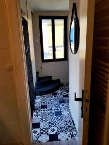 鲁昂Appartement typique Rouen centre tout confort的走廊铺有黑白瓷砖地板。