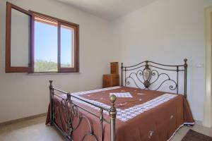 莱乌卡Ca Masci - Lovely House in Leuca的一间卧室配有一张带金属框架的床和窗户