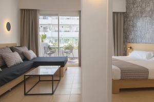 马盖鲁夫HM马提尼克酒店的一间卧室配有一张床、一张沙发和一张桌子