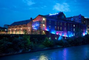都灵派西斐克弗尼诺酒店的河边的蓝色和紫色灯的建筑