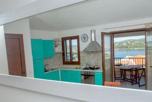 圣特雷莎加卢拉Fronte Mare Capo Testa的一个带蓝色橱柜的厨房和一个享有阳台景色的厨房