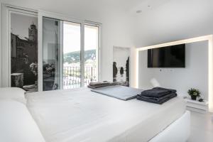 莱里奇Al Molo Sea View Rooms的白色的卧室设有一张白色大床和一个大窗户