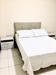 乌鲁瓜亚纳Morada Center的卧室配有白色的床和床头柜