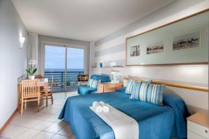 切塞纳蒂科巴尔韦德住宿酒店的一间卧室配有蓝色的床和桌椅