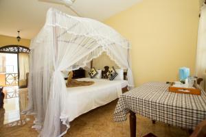 乌纳瓦图纳Hotel Dhammika的一间卧室配有一张带天蓬的床