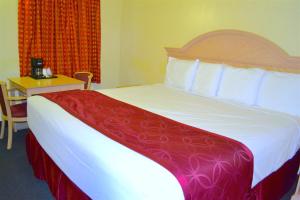 尼亚加拉瀑布尼亚加拉瀑布帕斯波特酒店的一间卧室配有一张大床,铺有红白毯子