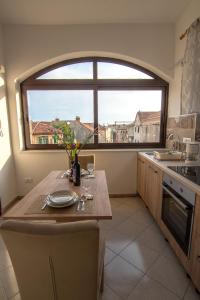 希贝尼克Apartment Batinica的厨房配有桌子和大窗户