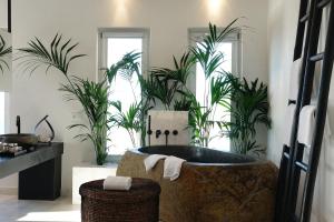 米克诺斯城爱玛仕米克诺斯酒店的浴室配有植物浴缸。