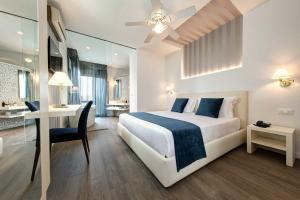 利多迪耶索罗拜伦贝拉维斯特酒店的酒店客房带一张床铺、一张书桌和一间卧室