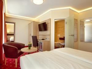 慕尼黑科瑞姆希尔德西斯嘉登酒店的配有床、椅子和桌子的酒店客房