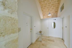 科拉托Le Stanze di Filippo Tandoi的一条带白色墙壁和砖墙的走廊