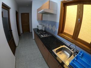 伊兹奎尔多Pozo Izquierdo Homelidays的一间带水槽和炉灶的小厨房