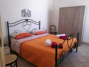 托雷科里梅纳Cala del Conte的卧室配有一张带橙色床单和枕头的大床。