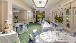 海华德希思桦树酒店的宴会厅配有白色的桌子和蓝色的椅子