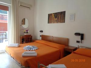 里米尼Hotel Lariana的卧室内的两张床,配有橙色床单