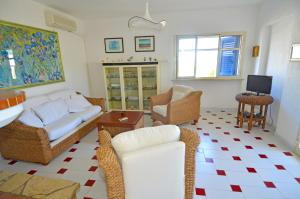 莱乌卡Casa Tramonto - RosariaVacanze的客厅配有沙发、椅子和电视