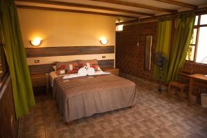 SauceLas Jawas Lodge的一间卧室配有一张带绿色窗帘的大床