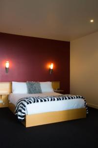 GrindelwaldRiver Vineyard Retreat的一间卧室设有一张红色墙壁的大床